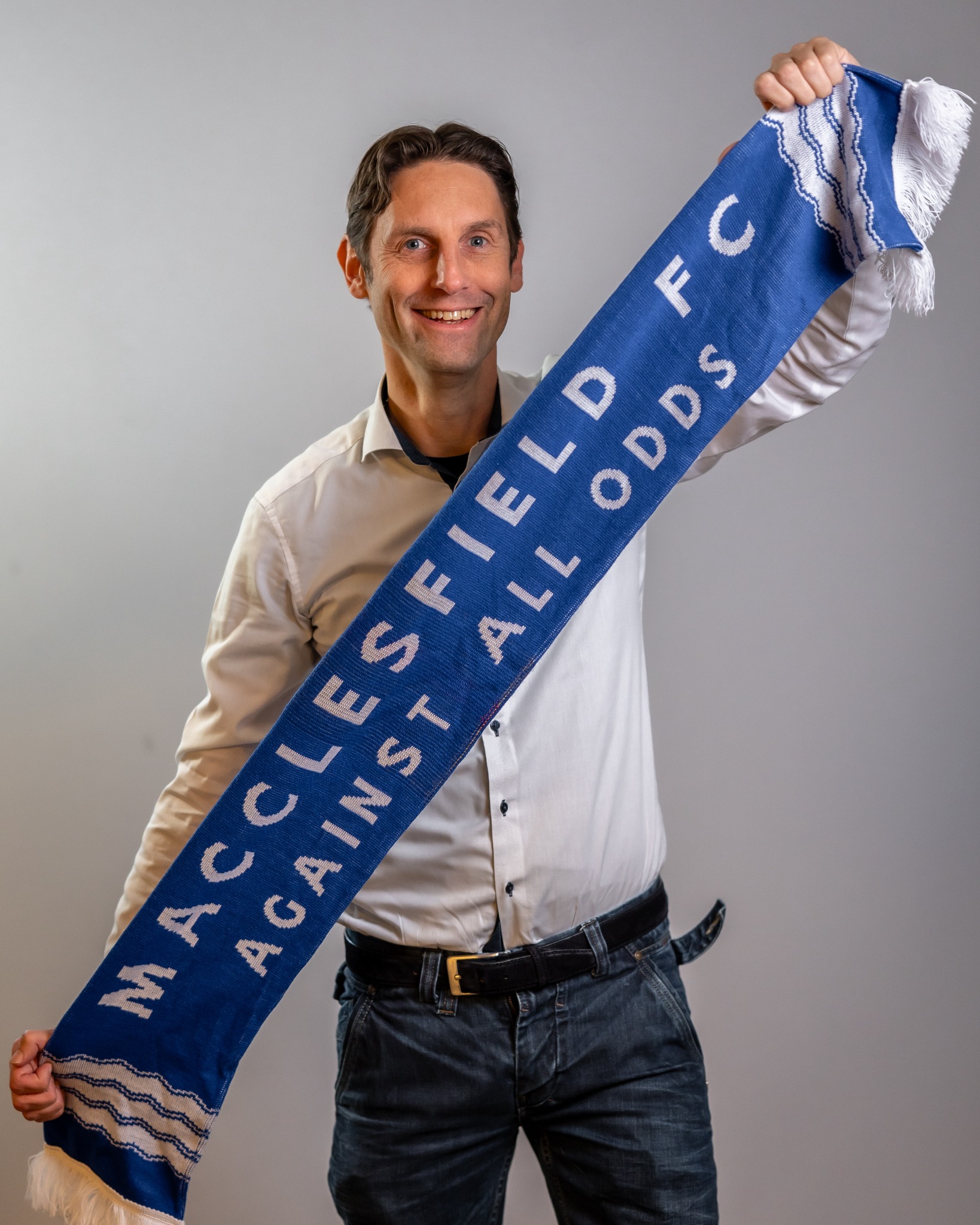 Ronnie the Silkman met een blauw-witte Macclesfield FC-sjaal